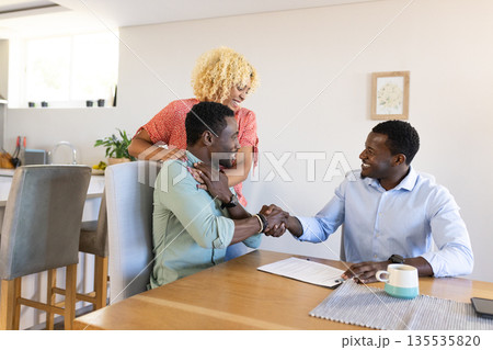 African American friends shaking hands at home, celebrating successful agreement 135535820