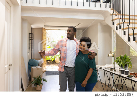 African American couple happily exploring new home, embracing and smiling together 135535887