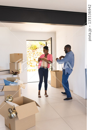 Couple joyfully unpacking boxes in new home, celebrating moving day together 135536942
