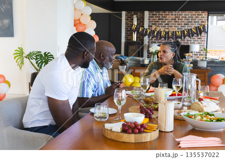 Celebrating retirement, friends sharing food and drinks, telling stories at home 135537022
