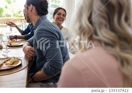 Laughing and having fun, friends at wedding reception table in conversation 135537422