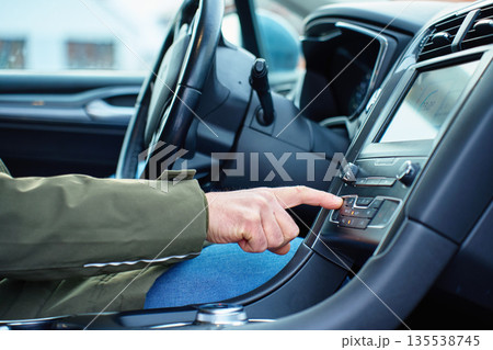 Hand pressing car dashboard button on climate control panel inside vehicle Hand pressing car dashboard button on climate control panel inside vehicle 135538745