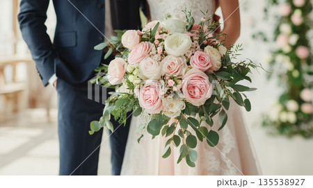 結婚披露宴でウェディングブーケを持つ新郎新婦のクロースアップ 135538927