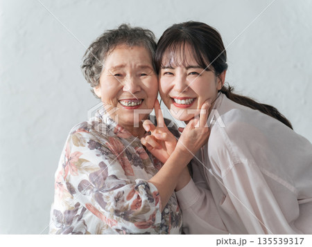 笑顔で寄り添うおばあちゃんと孫娘 笑顔で寄り添うおばあちゃんと孫娘 135539317