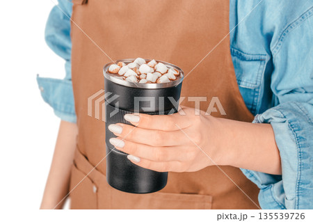 Woman holding reusable cup of hot chocolate with marshmallows on white background Woman holding reusable cup of hot chocolate with marshmallows on white background 135539726