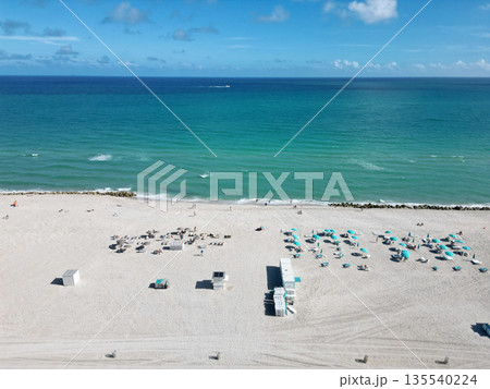 Enjoying beach sun. Summer vacation. Beach vacation at sea in summer. Sea relax under beach umbrella. Travel to sea. Aerial top view of sand beach with crystal clear turquoise water. Luxury resort Enjoying beach sun. Summer vacation. Beach vacation at sea in summer. Sea relax under beach umbrella. Travel to sea. Aerial top view of sand beach with crystal clear turquoise water. Luxury resort 135540224
