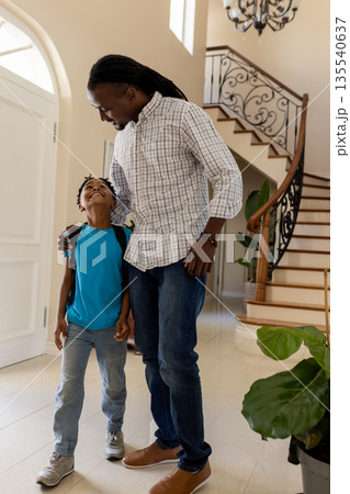 Father and son sharing joyful moment in bright home hallway Father and son sharing joyful moment in bright home hallway 135540637