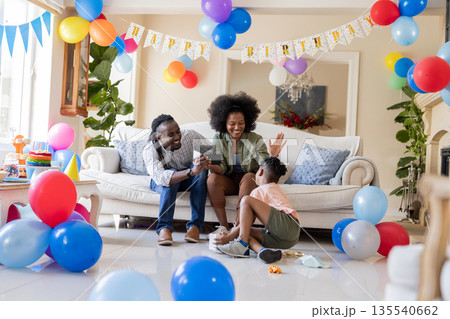 African American family celebrating birthday with balloons, enjoying time together at home African American family celebrating birthday with balloons, enjoying time together at home 135540662