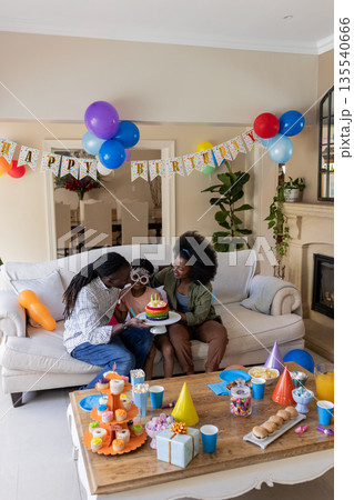 Celebrating birthday, African American family enjoying cake and decorations at home Celebrating birthday, African American family enjoying cake and decorations at home 135540666