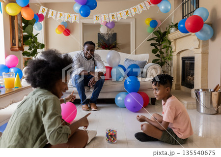 Family playing with colorful balloons, celebrating birthday and sharing quality time at home Family playing with colorful balloons, celebrating birthday and sharing quality time at home 135540675