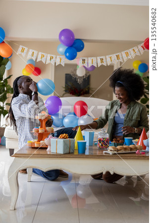 African American couple celebrating birthday with party decorations and treats at home African American couple celebrating birthday with party decorations and treats at home 135540682