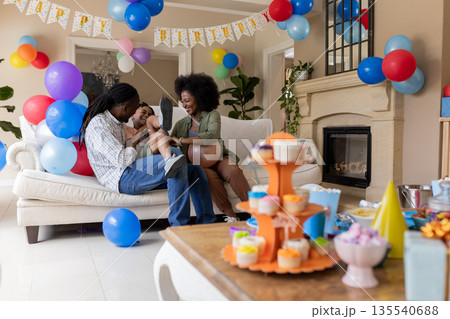 African American family celebrating birthday at home with balloons and cupcakes 135540688