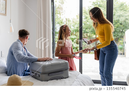 Family preparing for vacation, packing suitcase and checking smartphone at home 135540745