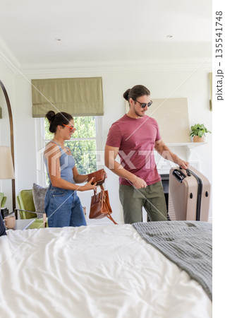 Couple arriving at hotel room with luggage, preparing for wedding celebration 135541748
