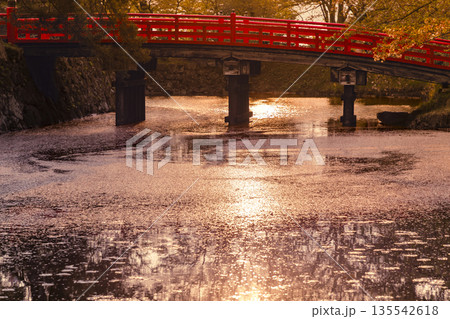 夕暮れに映える赤い橋と水面の風景 135542618
