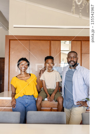 Smiling family of three enjoying quality time together in modern kitchen 135542967