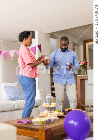 Celebrating at home, couple preparing snacks for festive family gathering 135543073