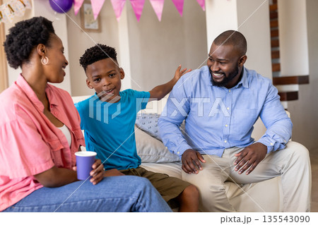 Happy family enjoying quality time together at home, smiling and talking Happy family enjoying quality time together at home, smiling and talking 135543090