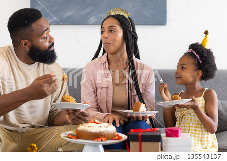 Celebrating birthday, happy family enjoying cake together on living room sofa 135543137