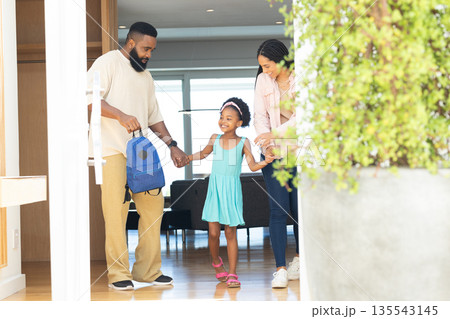 Preparing for school, parents holding child's hands, smiling together at home Preparing for school, parents holding child's hands, smiling together at home 135543145