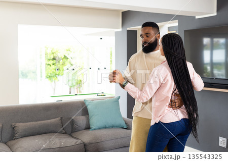 African American couple dancing together at home, enjoying joyful moment 135543325