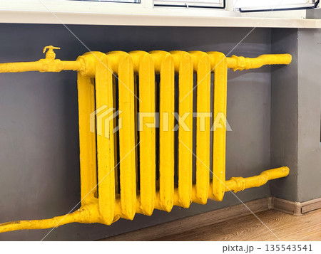 Yellow painted radiator under window in home interior. Yellow painted radiator under window in home interior. 135543541