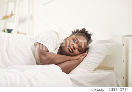 Young woman sleeping sweetly in cozy bedroom at modern home interior in the morning 135543784