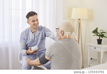 Nurse measure blood pressure of a sick senior mature male patient visiting him at home. Nurse measure blood pressure of a sick senior mature male patient visiting him at home. 135543791