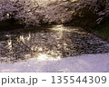 川沿いに咲く桜並木と水面の花びら 135544309