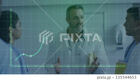 Medical team analyzing digital graph in hospital corridor with stethoscope, folder and clipboard 135544653