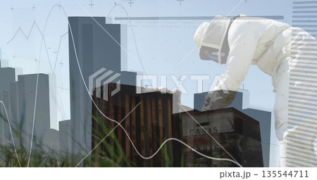 Leaning beekeeper in suit inspecting hives on grass, with skyline and graph overlays, copy space Leaning beekeeper in suit inspecting hives on grass, with skyline and graph overlays, copy space 135544711