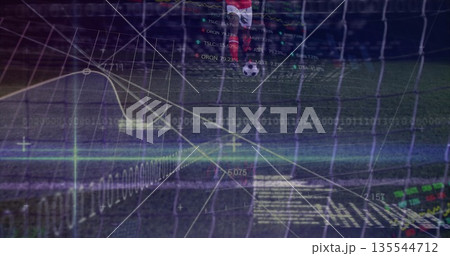 Kicking soccer player in red jersey driving ball toward goal net on pitch, with data overlays Kicking soccer player in red jersey driving ball toward goal net on pitch, with data overlays 135544712