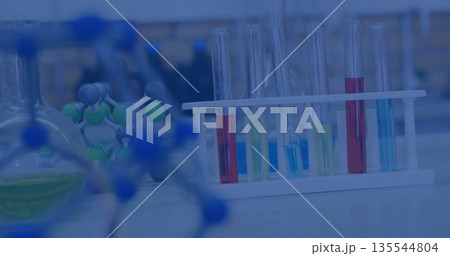 Displaying white plastic test tube rack holding colored liquids on lab bench, with molecular models 135544804