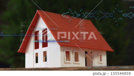 Displaying scale model house featuring red roof white walls on wooden table with digital overlay Displaying scale model house featuring red roof white walls on wooden table with digital overlay 135544859