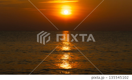 Sunrise over the sea with warm orange light and a calm morning atmosphere Sunrise over the sea with warm orange light and a calm morning atmosphere 135545102