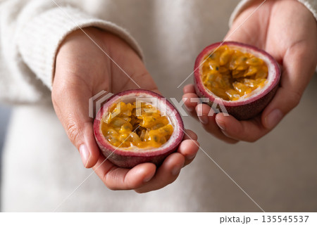 Fresh passion fruit holding by woman hand ready to eating, Tropical fruit 135545537