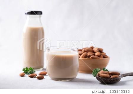 Almond milk and almond nuts on white fabric background, Alternative milk made from plant, Dairy free Almond milk and almond nuts on white fabric background, Alternative milk made from plant, Dairy free 135545556