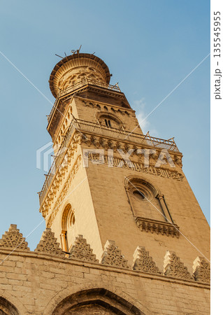 Historic Qalawun Complex in Cairo, featuring intricate architecture, tall minarets, and domes under a blue sky with clouds. A significant cultural landmark on Al-Muizz Street. 135545955