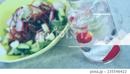 Displaying glass carafe showing strawberry-mint infused water in kitchen, with salad, data overlay 135546422