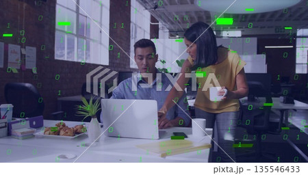 Collaborating man in shirt and woman in blouse pointing at laptop in office, with coffee mugs 135546433