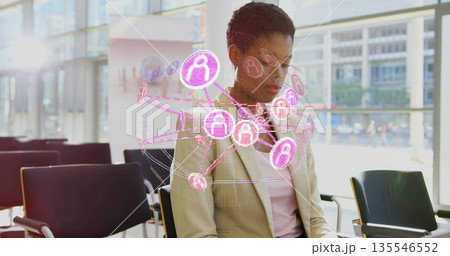 Observing man in blazer studying holographic network over chairs in lobby, pink user-icon nodes Observing man in blazer studying holographic network over chairs in lobby, pink user-icon nodes 135546552