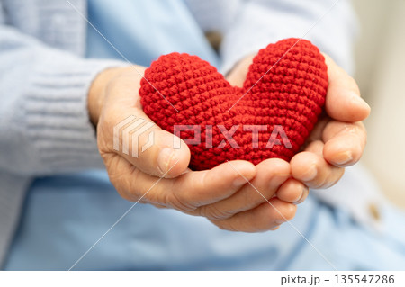 Asian woman holding red heart for health in hospital. Asian woman holding red heart for health in hospital. 135547286