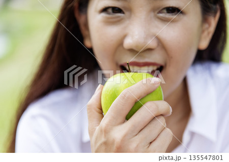 young asian woman eating Apple Healthy. Girl workout holding organic apple fruit healthy lifestyle. Wellness Asian women eat red apple smile face look at camera. Beauty health care lifestyle concept young asian woman eating Apple Healthy. Girl workout holding organic apple fruit healthy lifestyle. Wellness Asian women eat red apple smile face look at camera. Beauty health care lifestyle concept 135547801