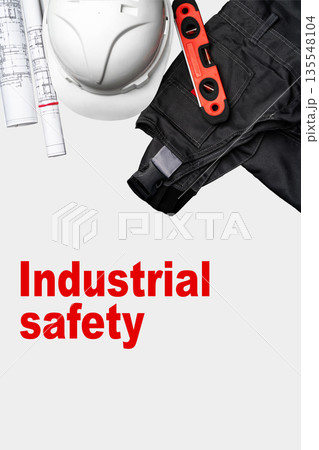 Industrial safety gear and tools on a clean surface with plans for construction work 135548104