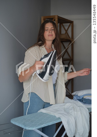 Work day preparation with brunette carefully ironing clothes creating order and an efficient morning routine Work day preparation with brunette carefully ironing clothes creating order and an efficient morning routine 135548449