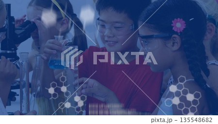 Mixing solution goggle-wearing children conducting experiment in school lab with graduated cylinder 135548682