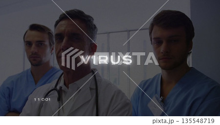 Standing doctor and scrub-clad staff consulting in hospital corridor, with stethoscope and badges Standing doctor and scrub-clad staff consulting in hospital corridor, with stethoscope and badges 135548719