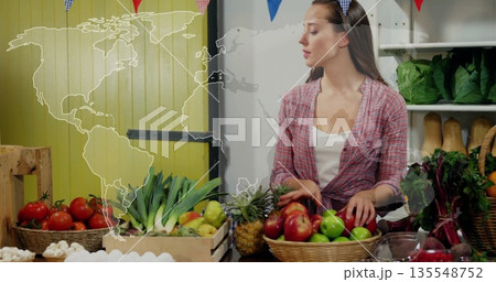 Produce vendor wearing red plaid shirt arranging fruits at market stall, with baskets of apples Produce vendor wearing red plaid shirt arranging fruits at market stall, with baskets of apples 135548752