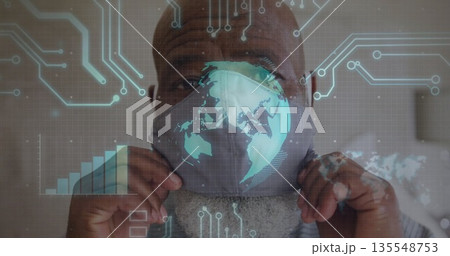 Mature man pulling gray mask over face in neutral room, with digital world map overlay Mature man pulling gray mask over face in neutral room, with digital world map overlay 135548753