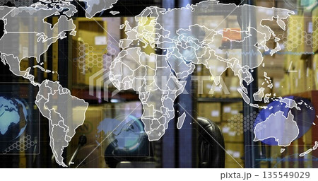 Displaying digital world map overlaying warehouse, with forklift seat, shelving racks and boxes 135549029
